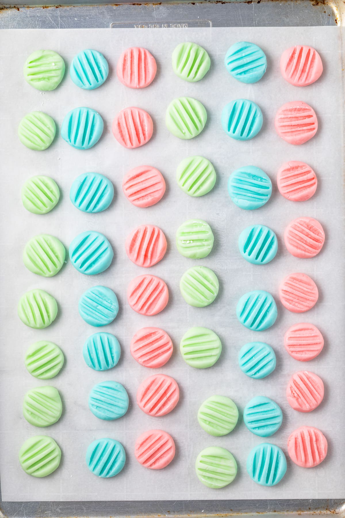 Cream cheese mints on a baking sheet lined with parchment paper.