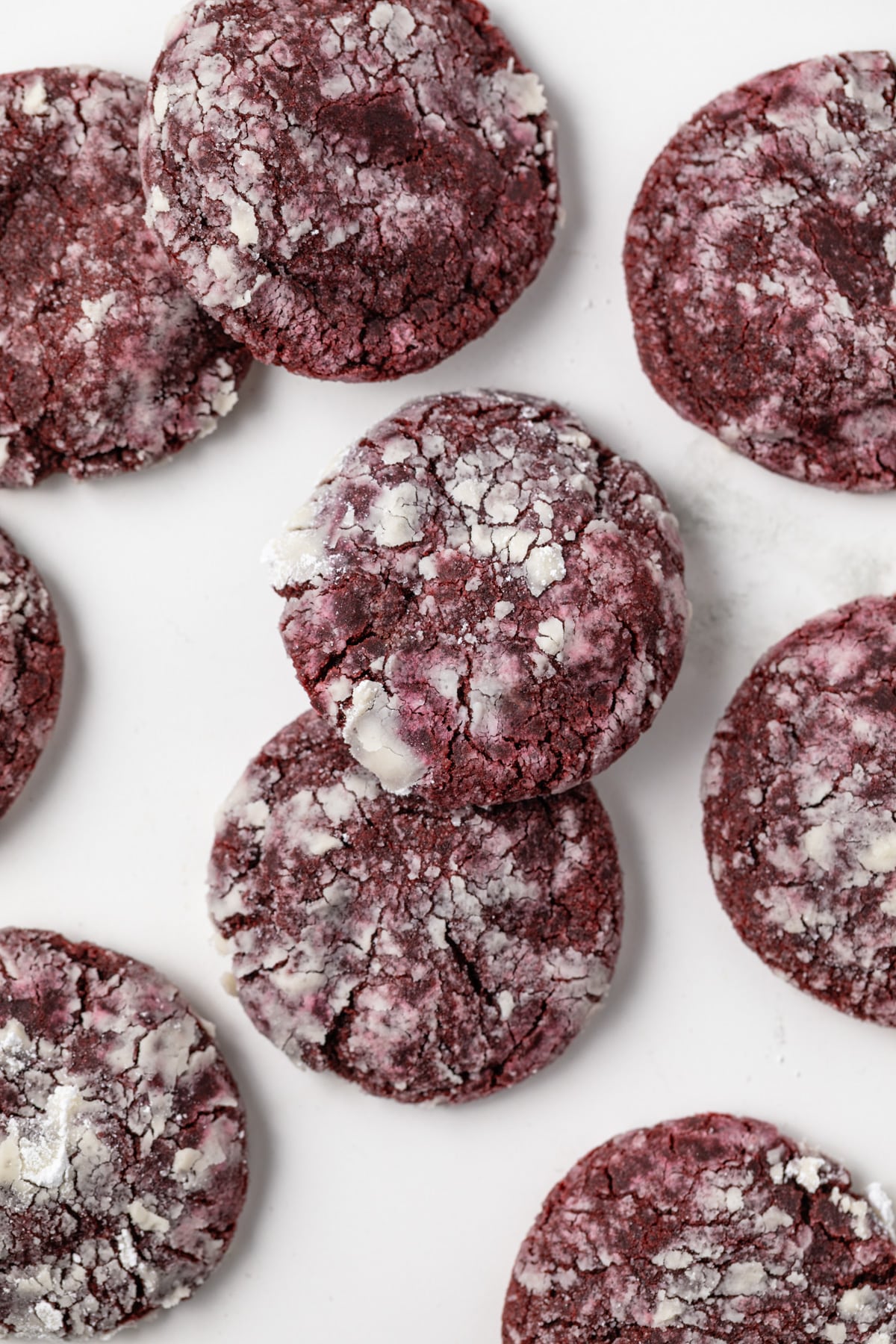 Overhead of red velvet crinkle cookies on parchment paper.