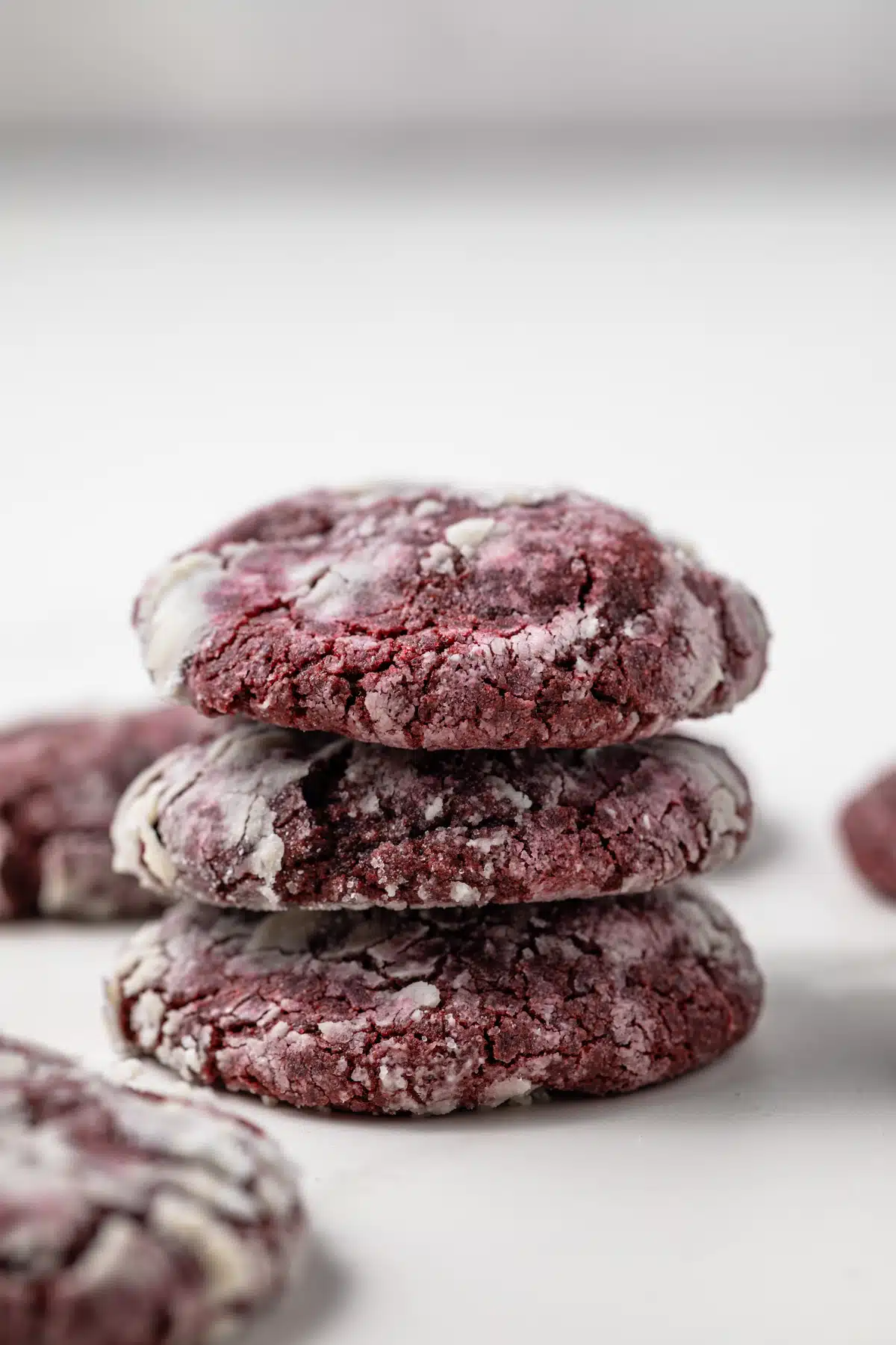 Three red velvet crinkle cookies stacked.