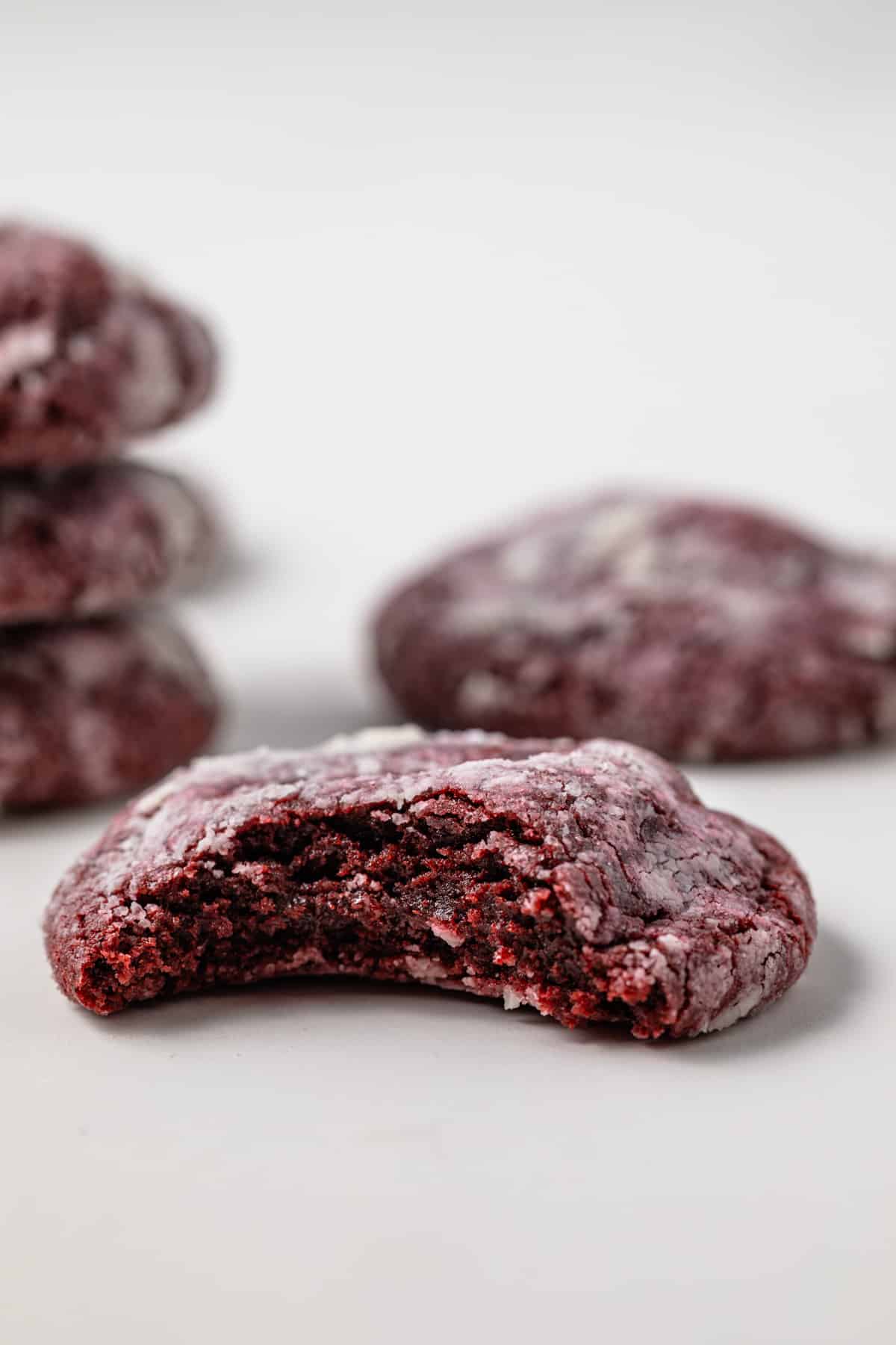 A bite taken out of a red velvet crinkle cookie.