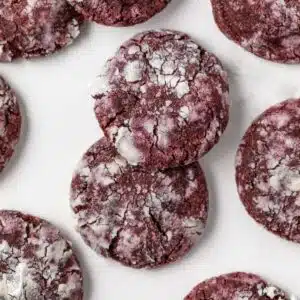 Overhead of red velvet crinkle cookies on parchment paper.