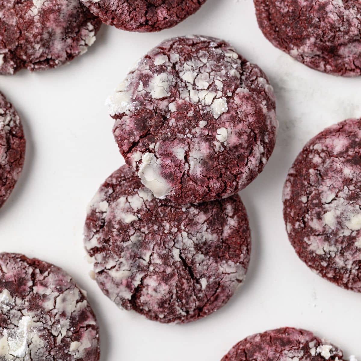 Overhead of red velvet crinkle cookies on parchment paper.