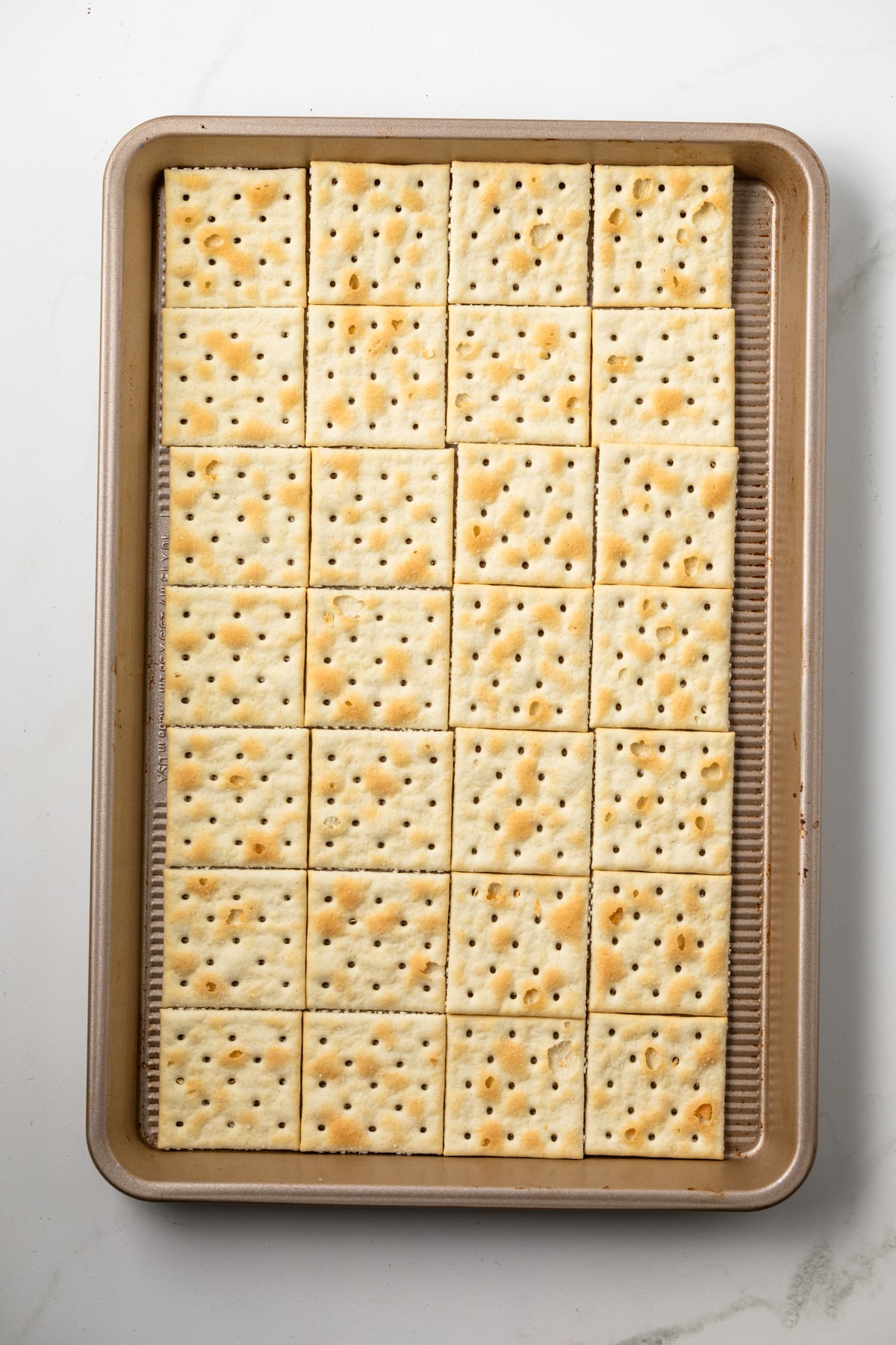 Saltine crackers on a baking sheet.