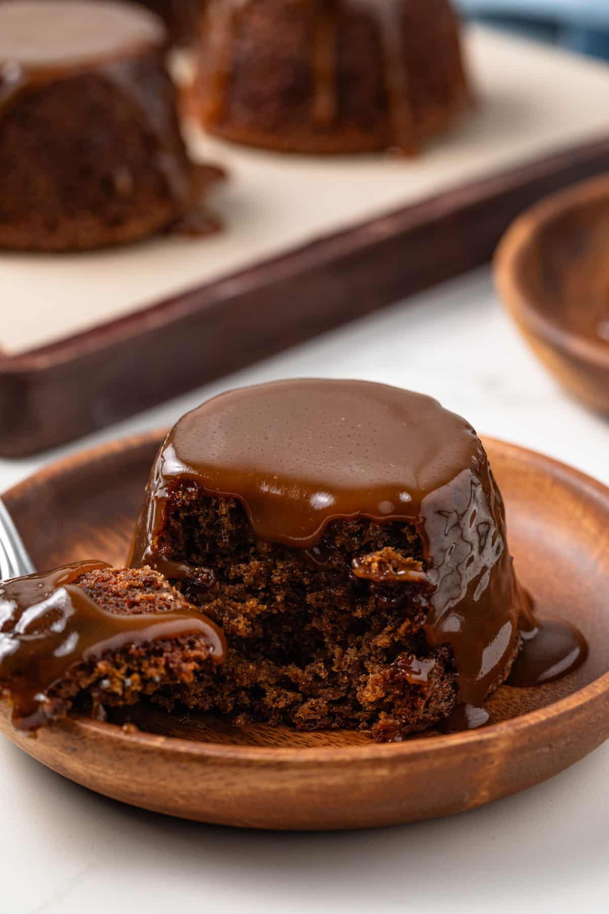 Sticky toffee pudding with a slice taken out by a fork.