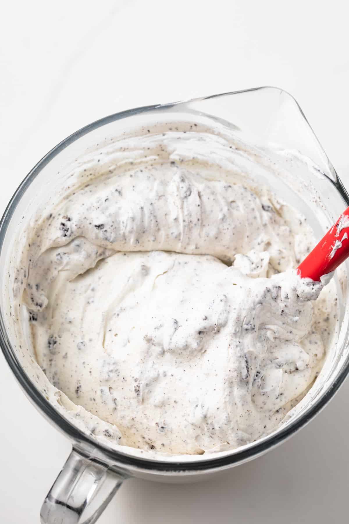 Whipped cream with Oreos in a glass bowl.