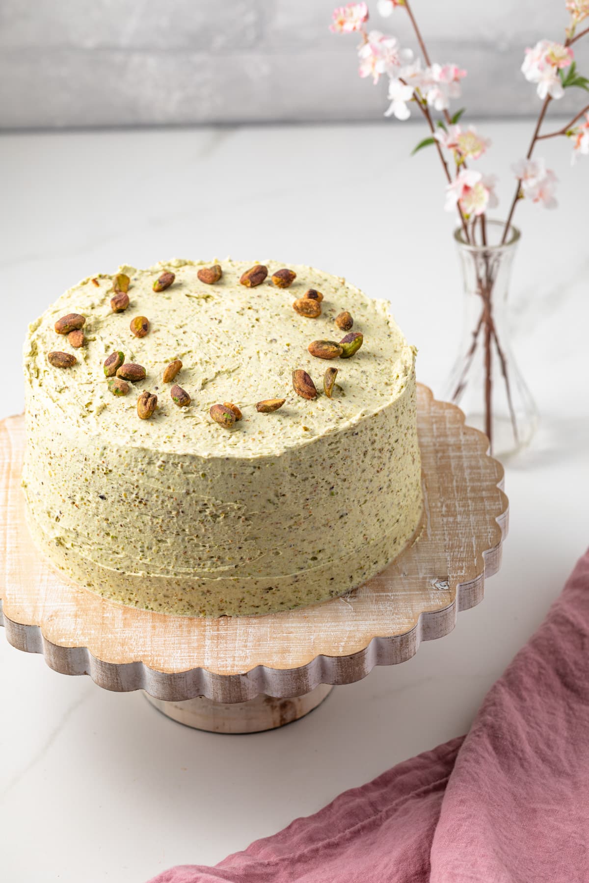 High angled view of pistachio cake on a cake stand.