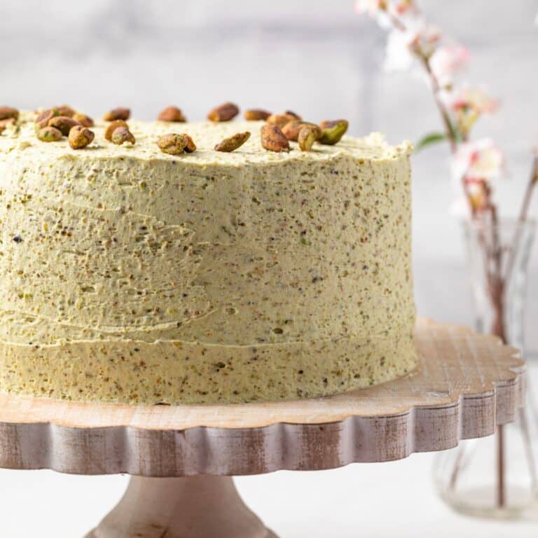 Side view of pistachio cake on a cake stand.