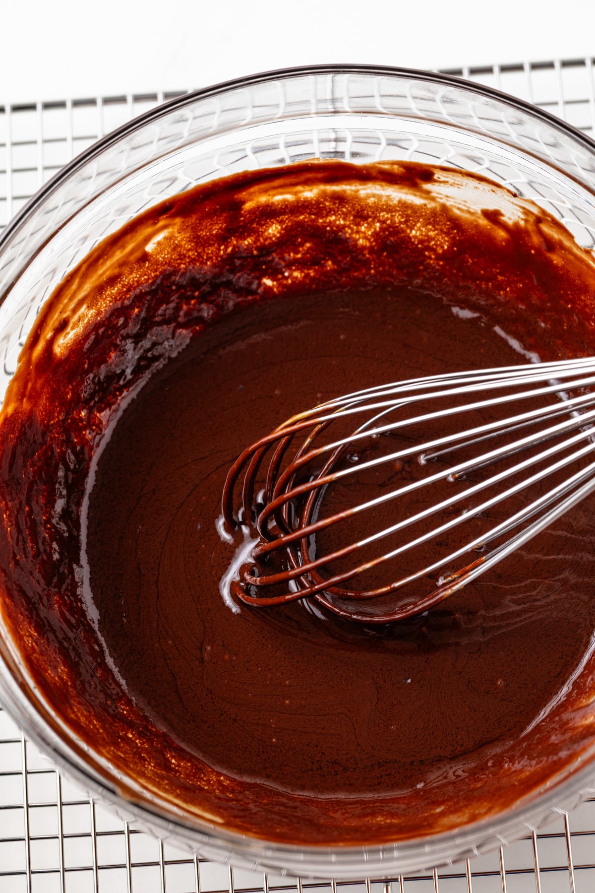 Chocolate and egg yolk mixed together in glass bowl.