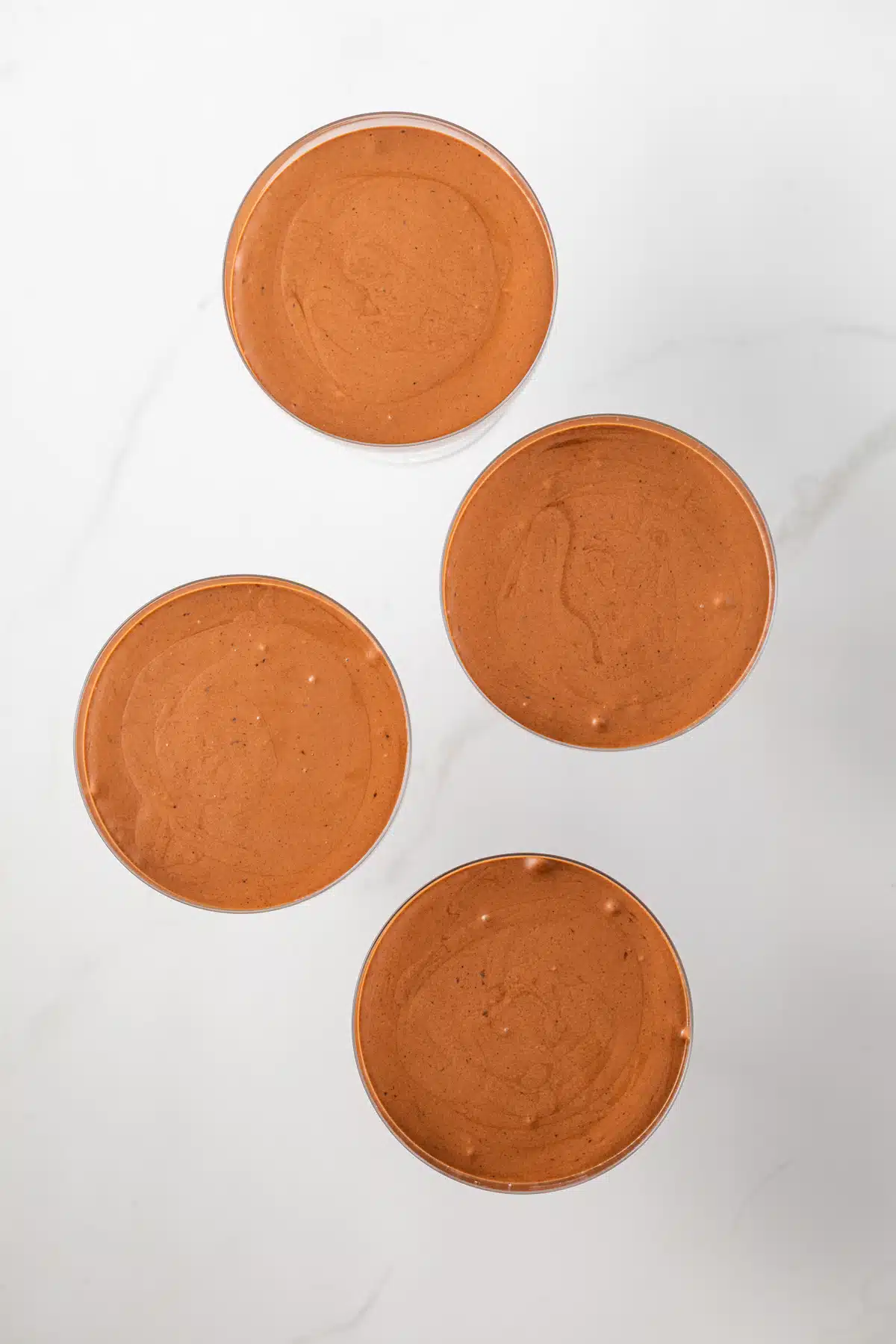 Overhead of mousse in 4 glass ramekins.