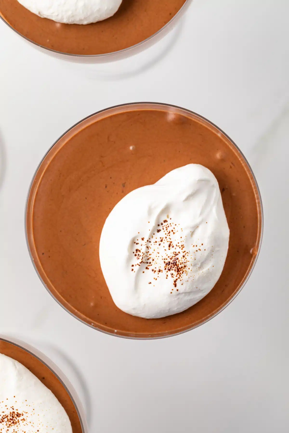 Overhead of chocolate coffee mousse topped with whipped cream.