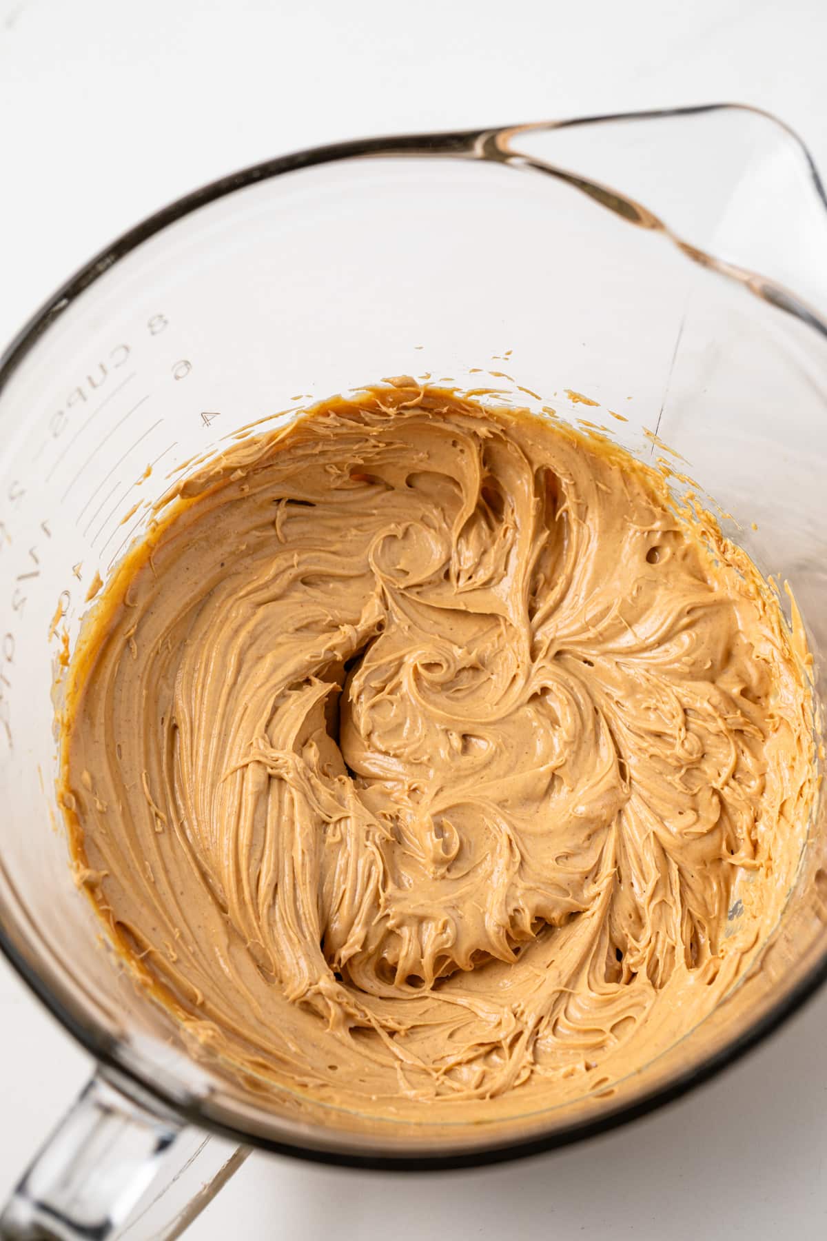 Peanut butter creamed with butter in a glass bowl.