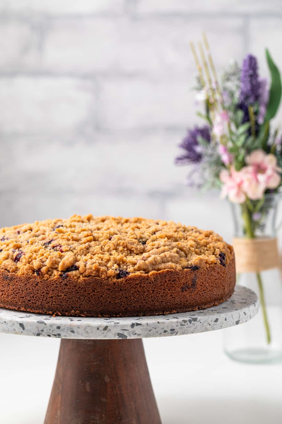 Side view of blueberry coffee cake on a cake stand.