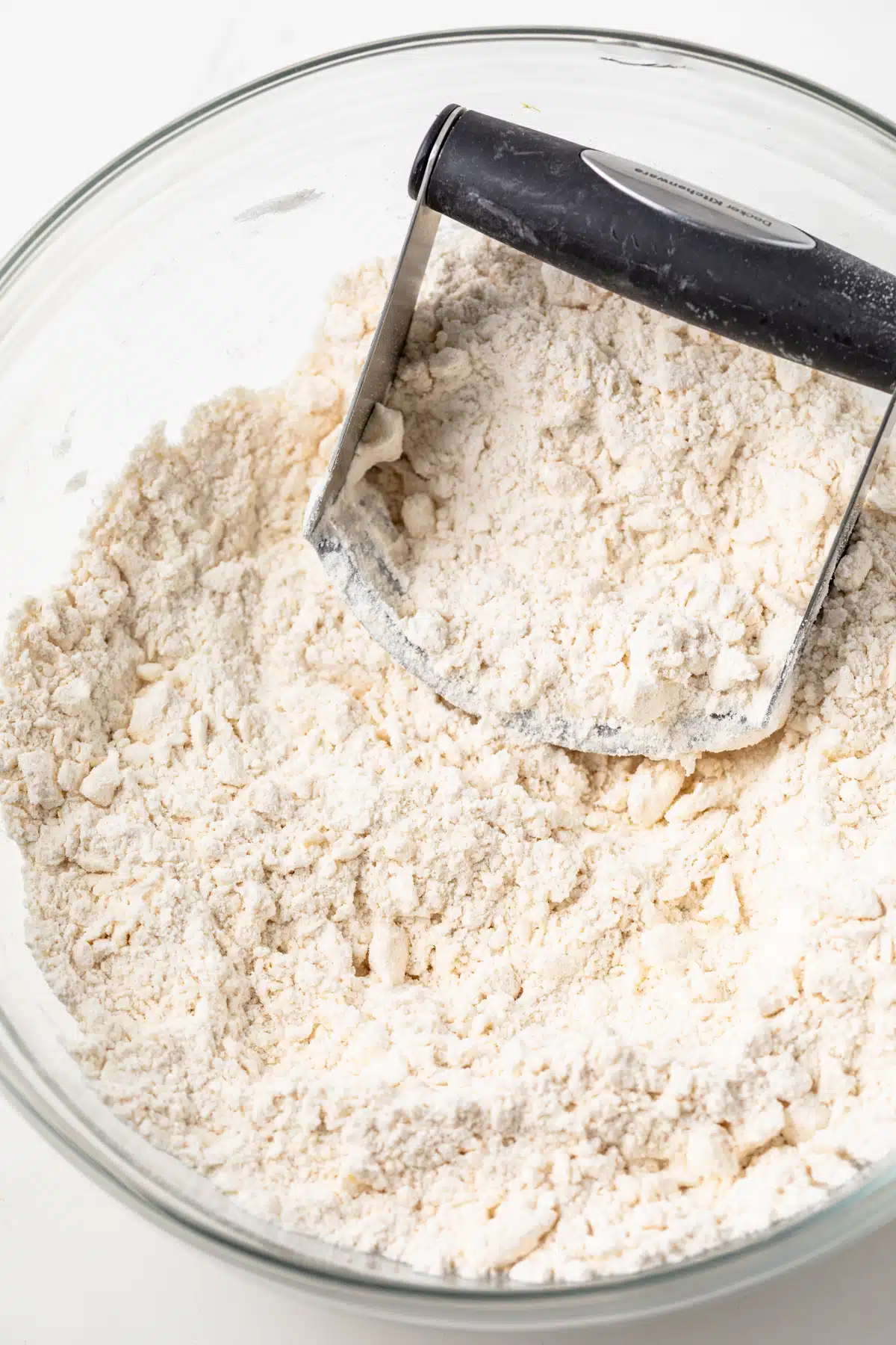 Butter cut into flour in a glass bowl.