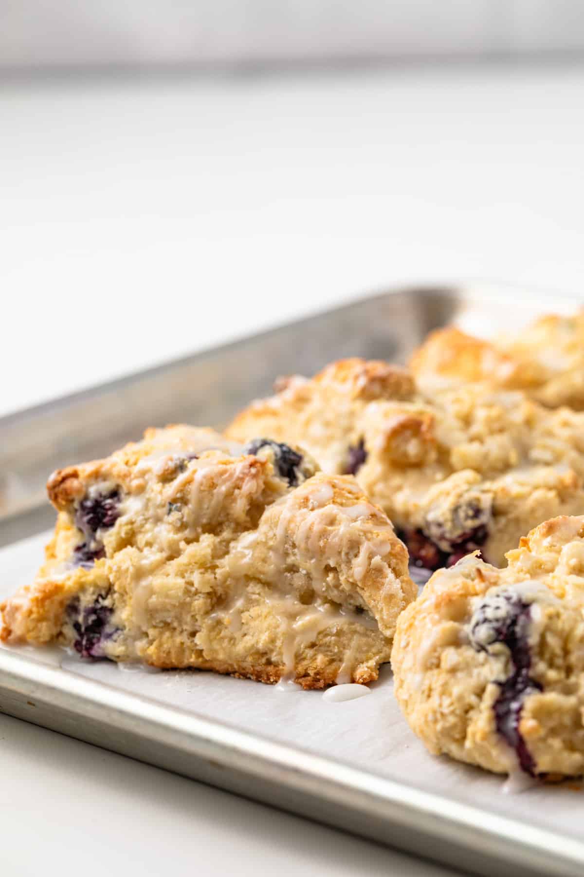 Side view of lemon blueberry scones on a baking sheet.