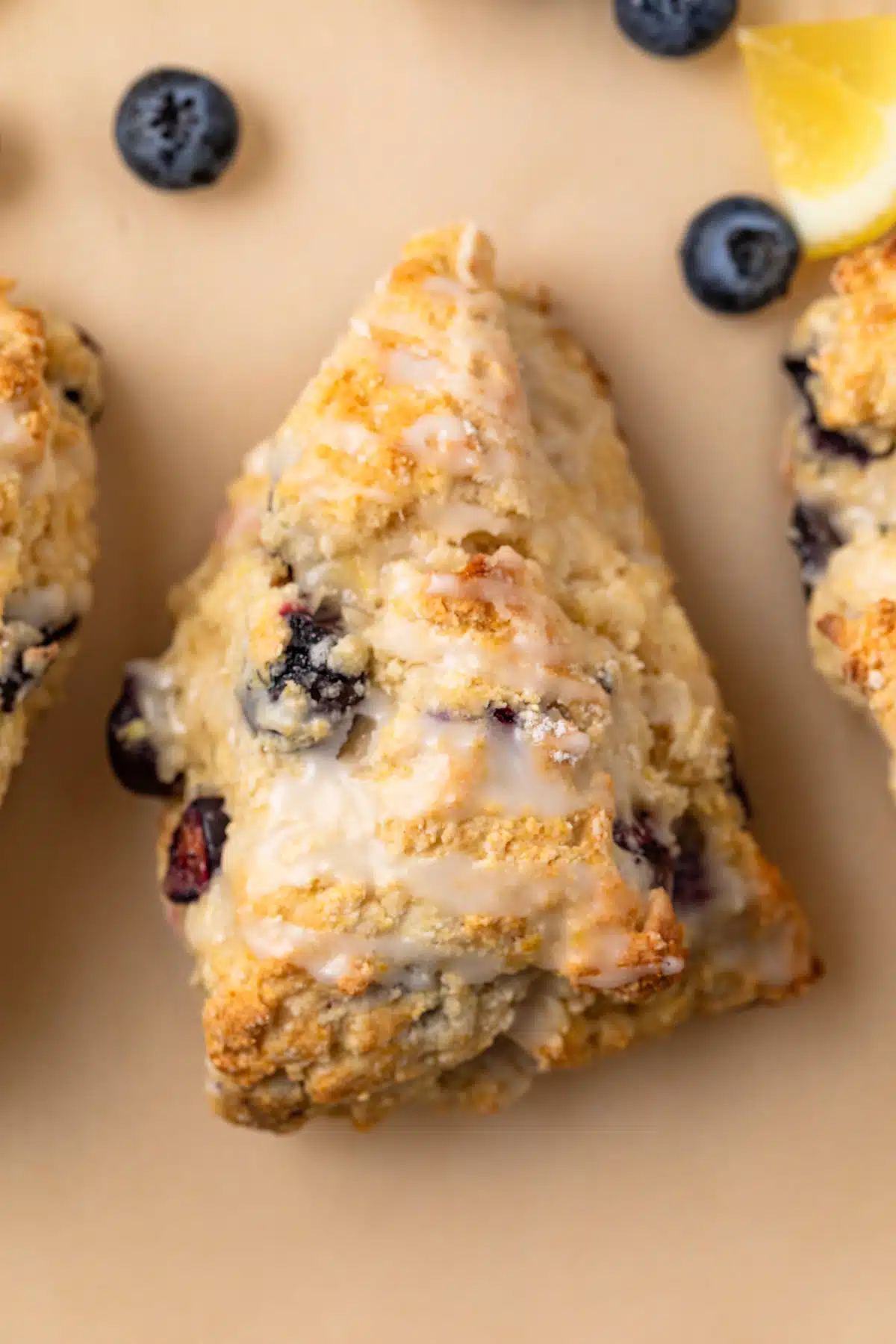 Overhead of a lemon blueberry scone on parchment paper.