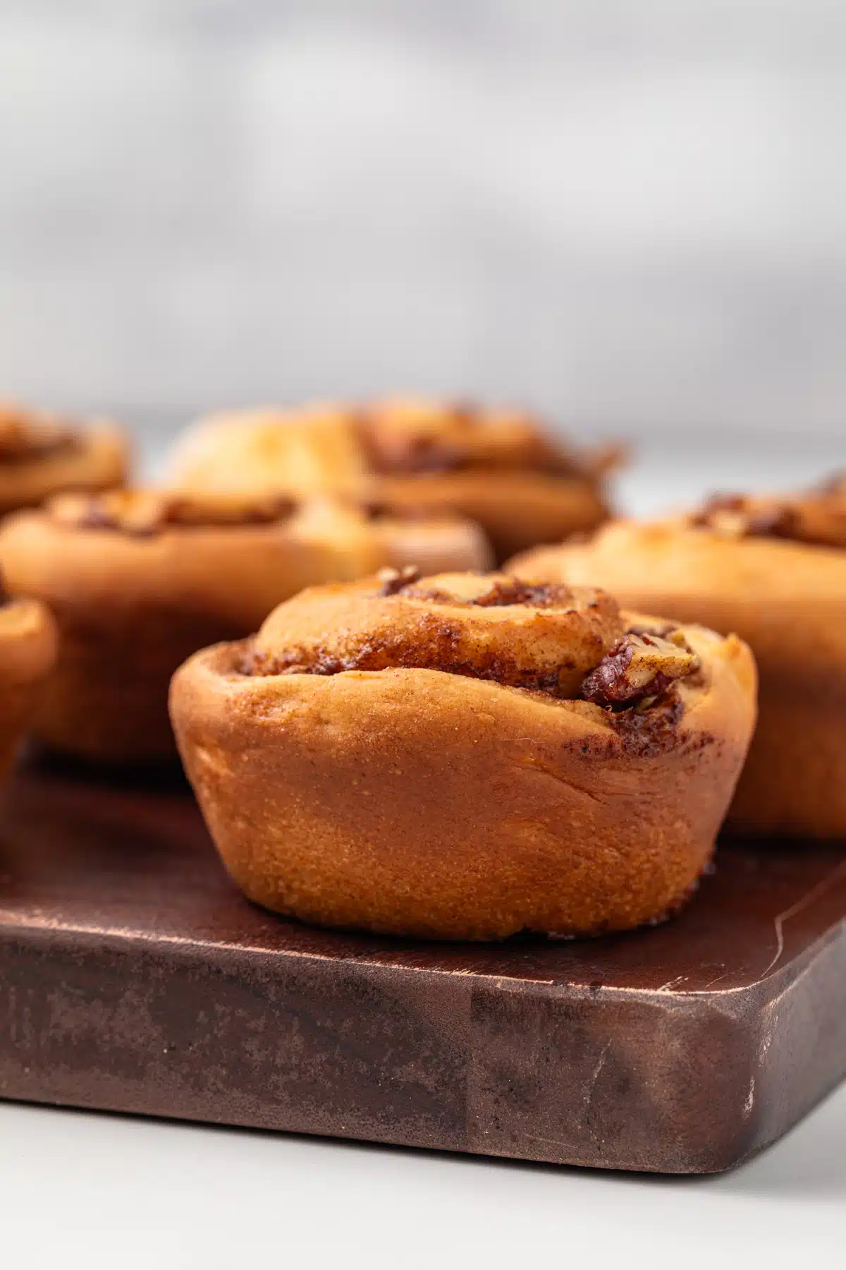 Side view of a pecan roll on a wood board.