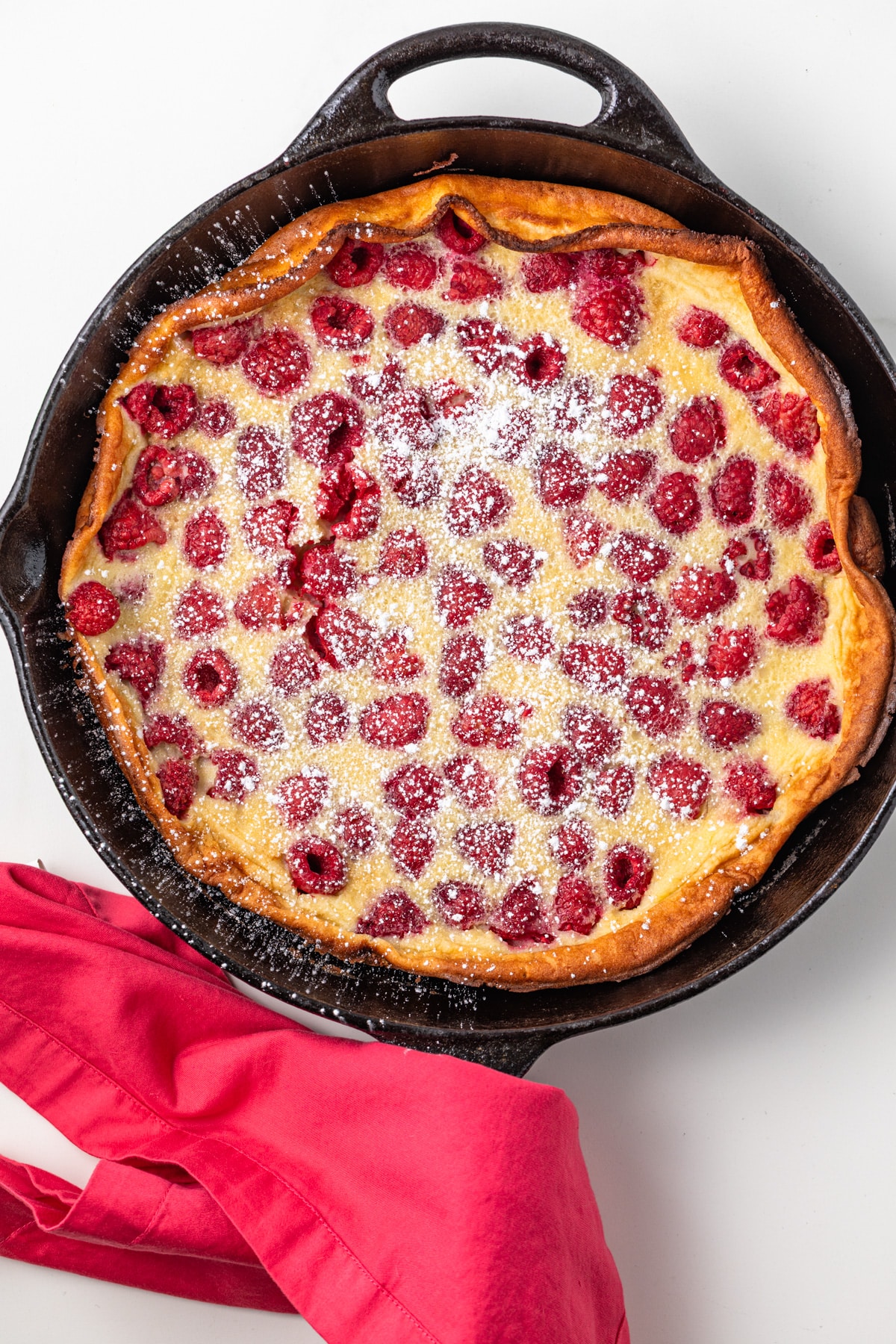 Raspberry almond clafoutis in a cast iron skillet.