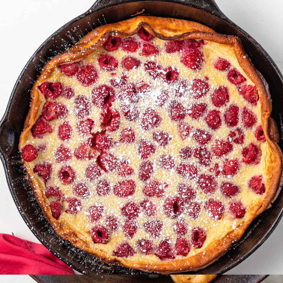 Raspberry almond clafoutis in a cast iron skillet.