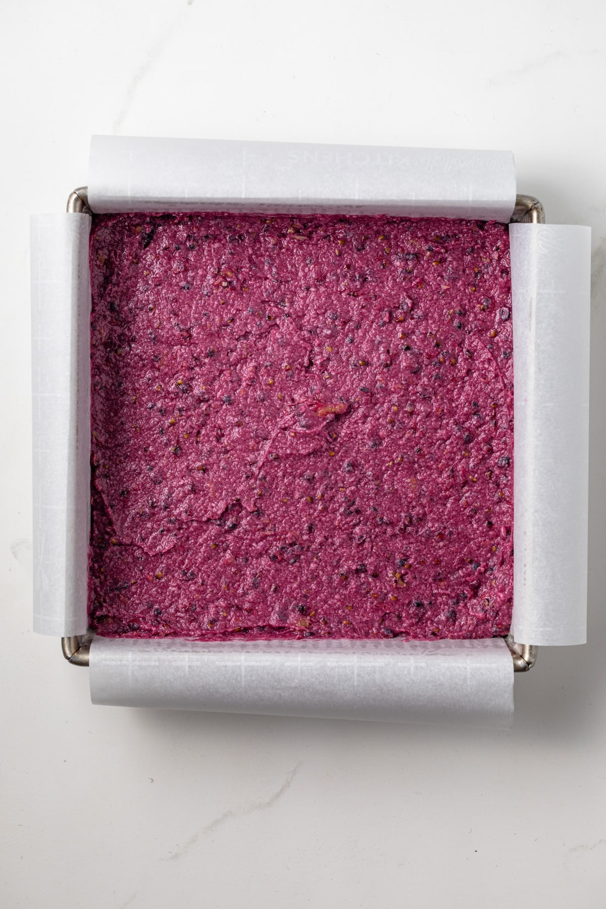 Unbaked blackberry lemon bars in a square pan.