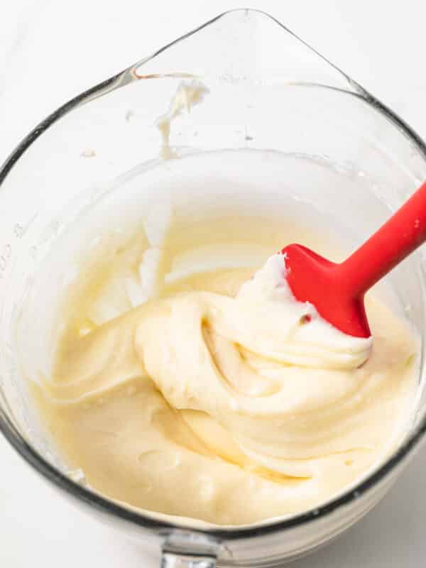 Cream cheese frosting in a glass bowl.