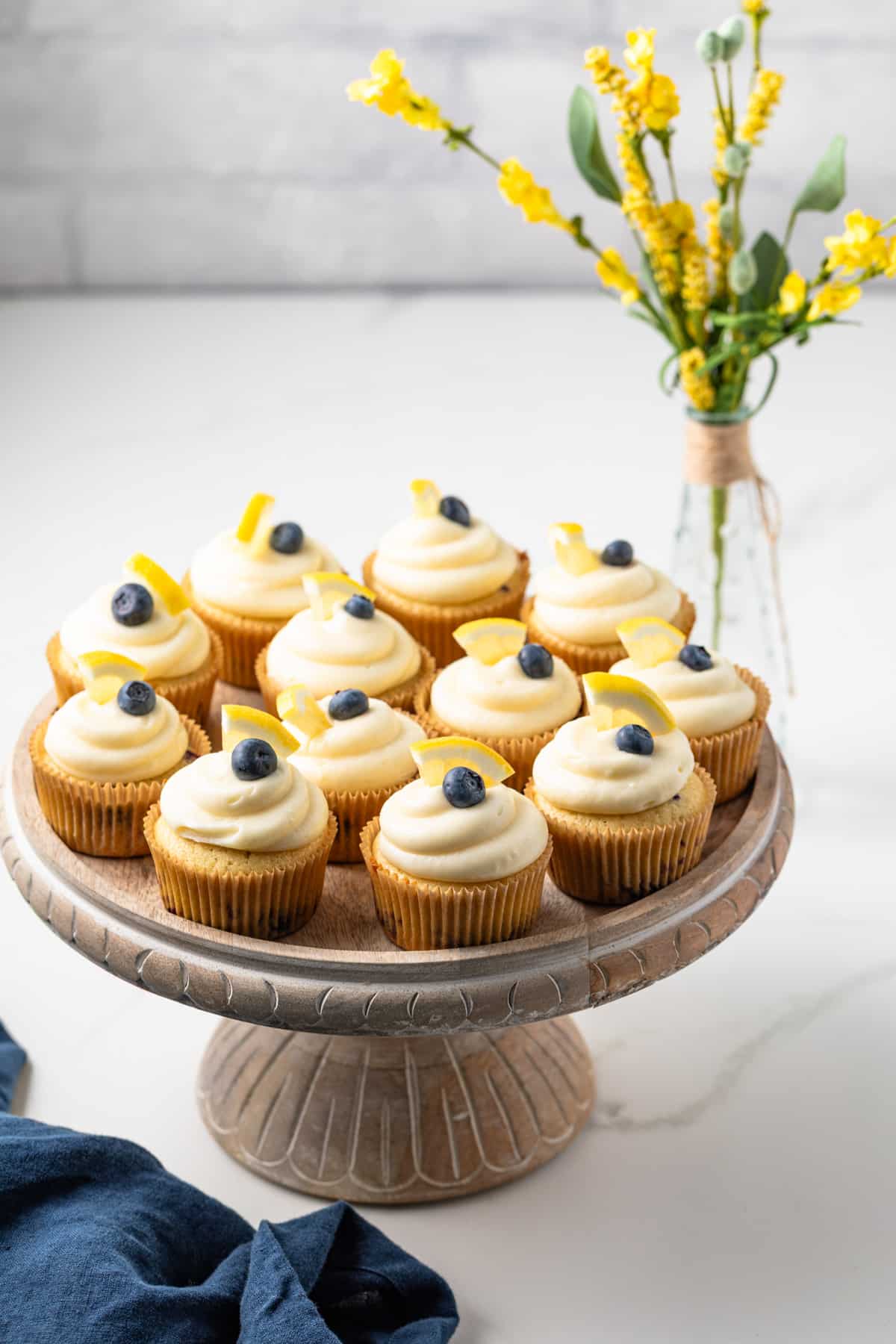 Lemon blueberry cupcakes on a cake stand.