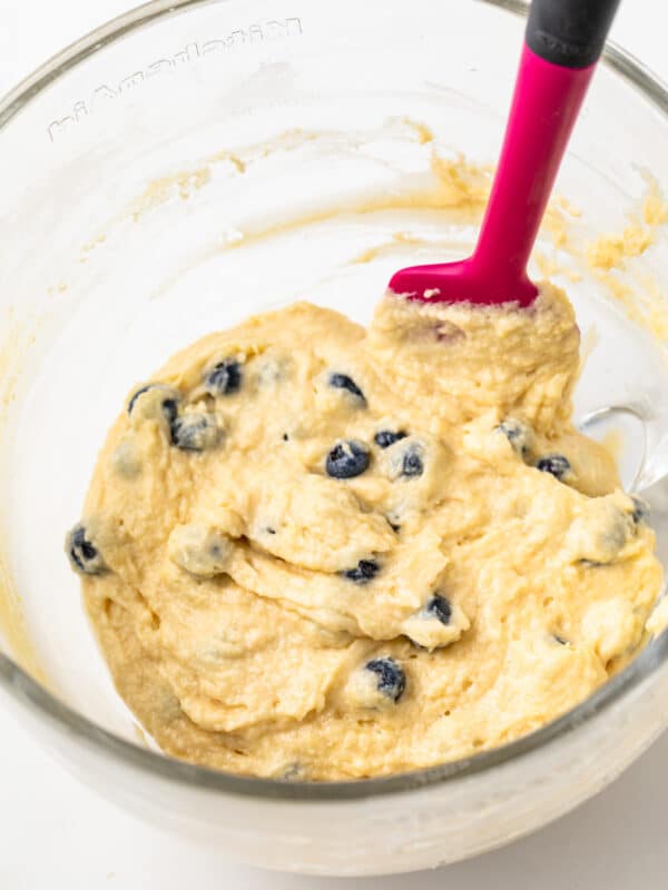 Lemon blueberry cupcake batter in a glass bowl.
