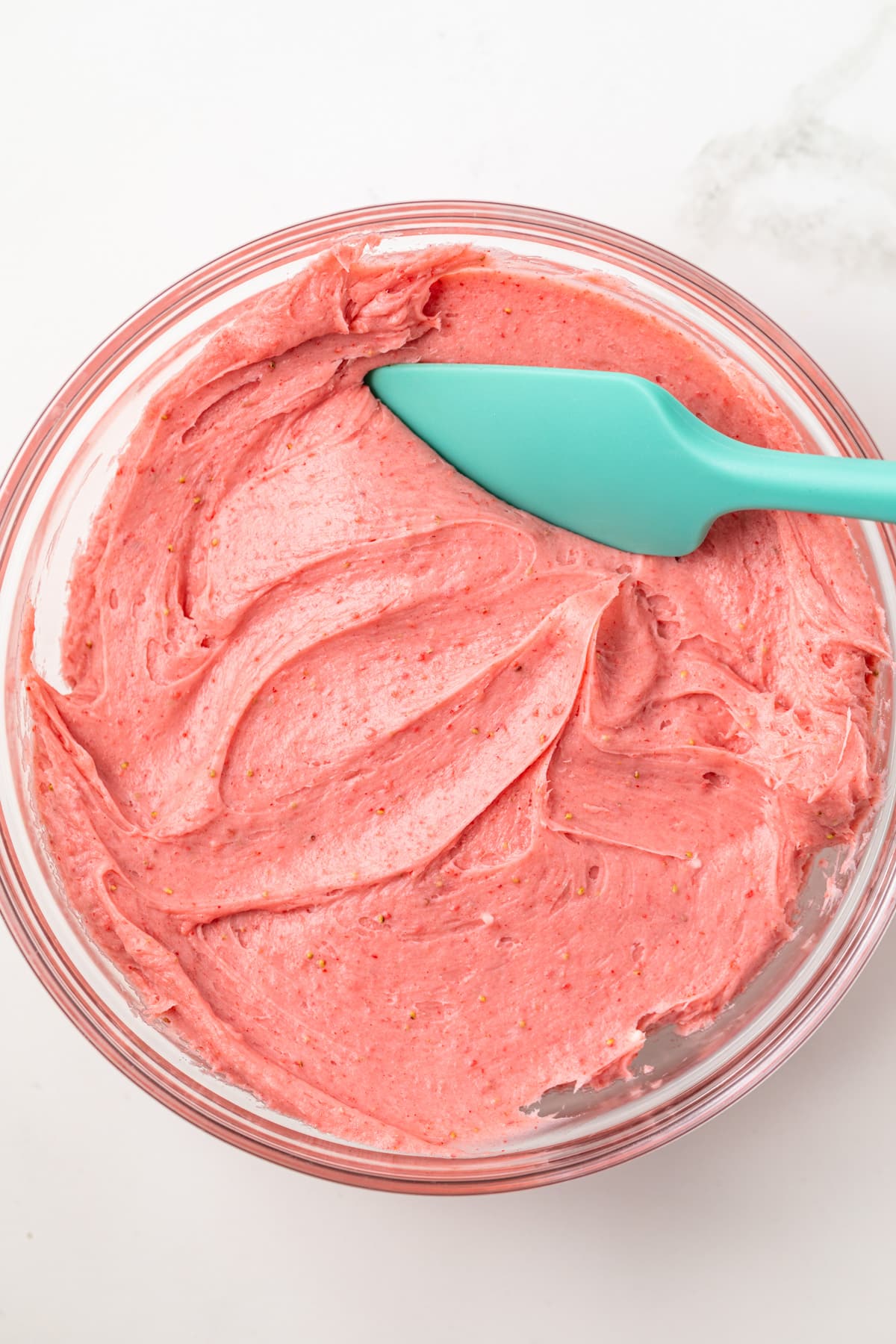 Strawberry cream cheese frosting in a glass bowl.