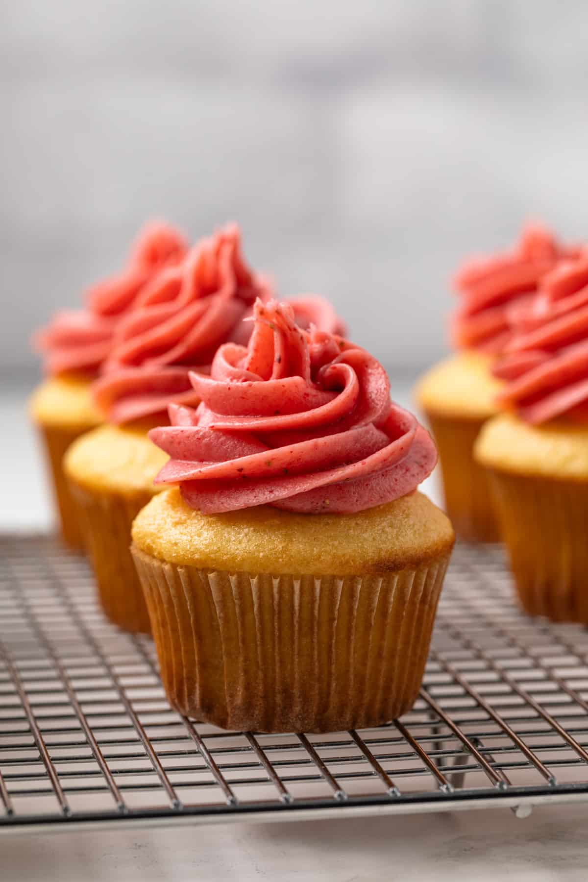 Strawberry cream cheese frosting swirled on top of cupcakes.