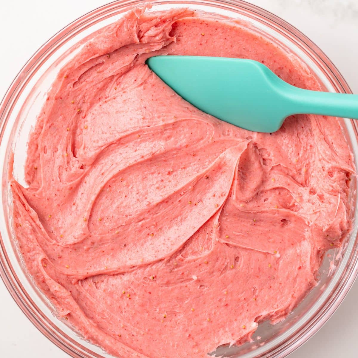 Strawberry cream cheese frosting in a glass bowl.