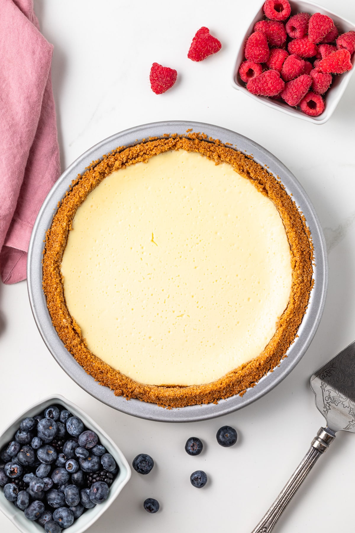 Overhead of cheesecake pie in metal pie plate.