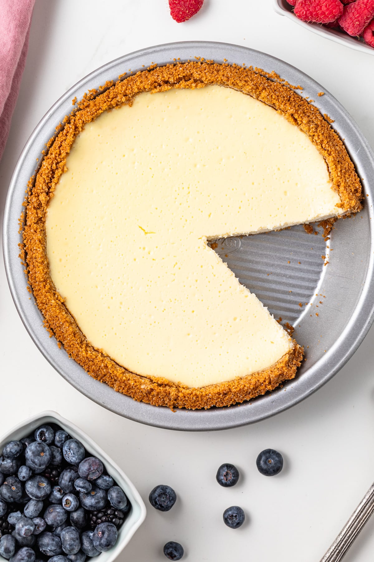 Slice taken out of cheesecake pie.