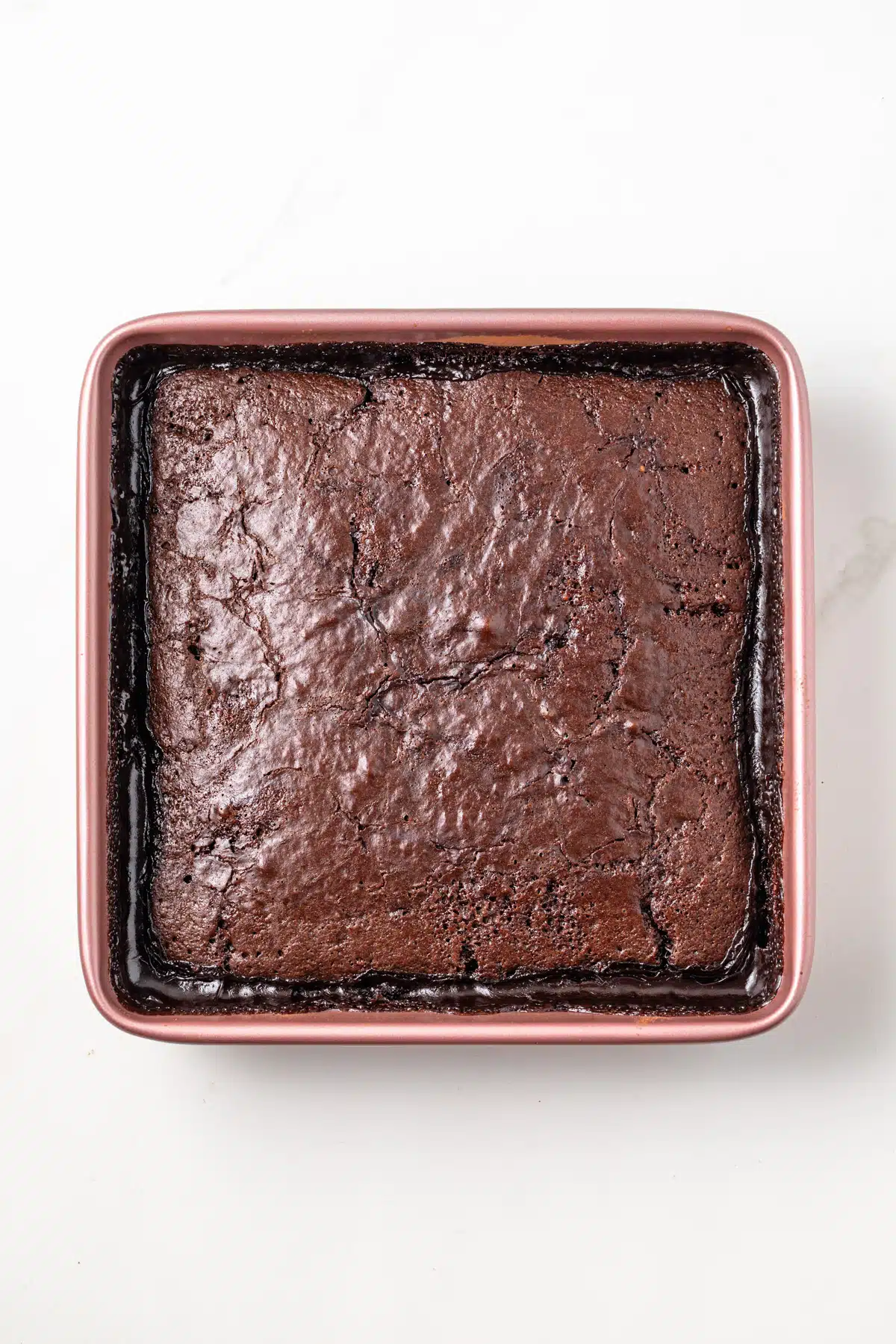 Overhead view of baked chocolate pudding cake in a square baking dish.
