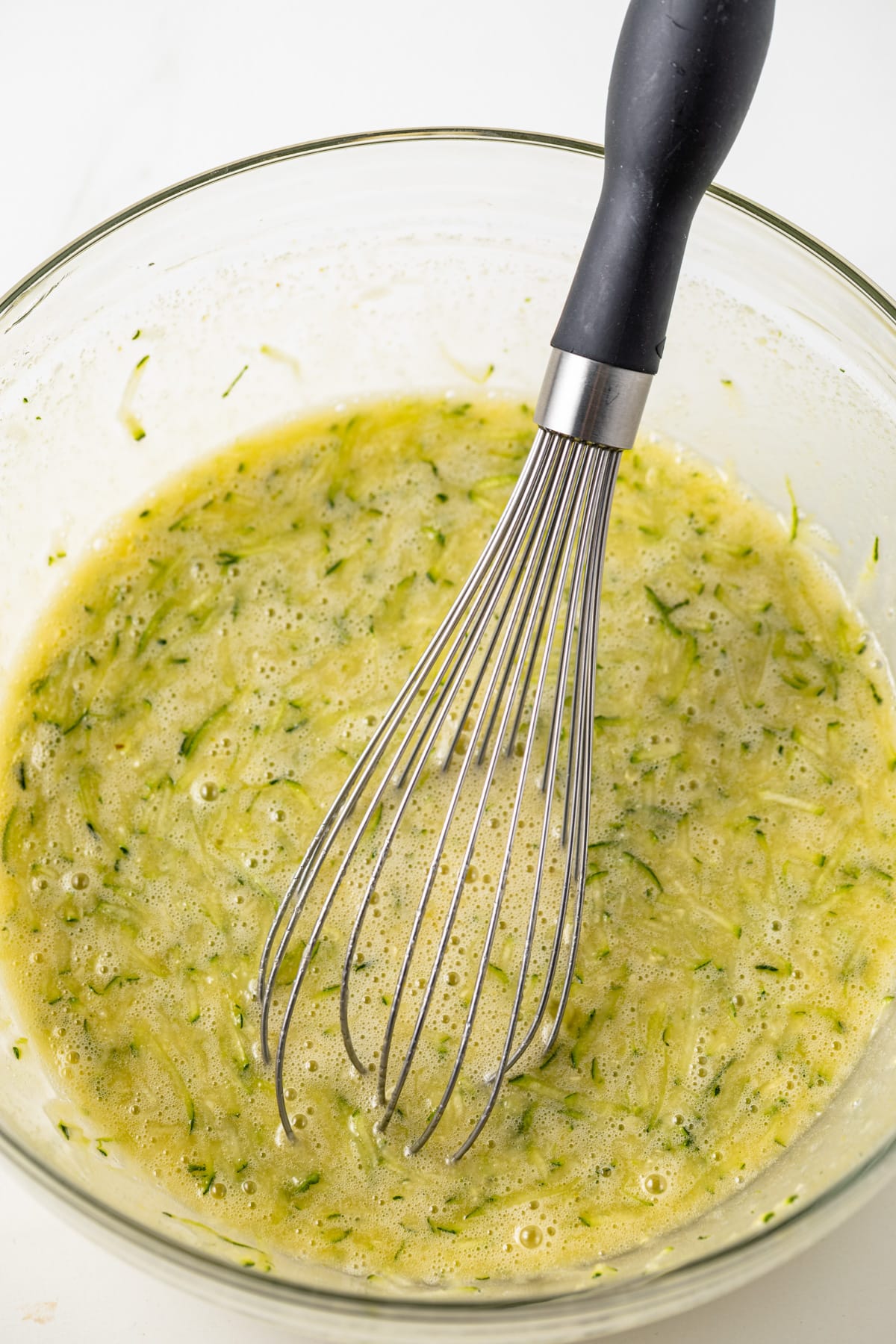 Wet ingredients mixed in a glass mixing bowl.