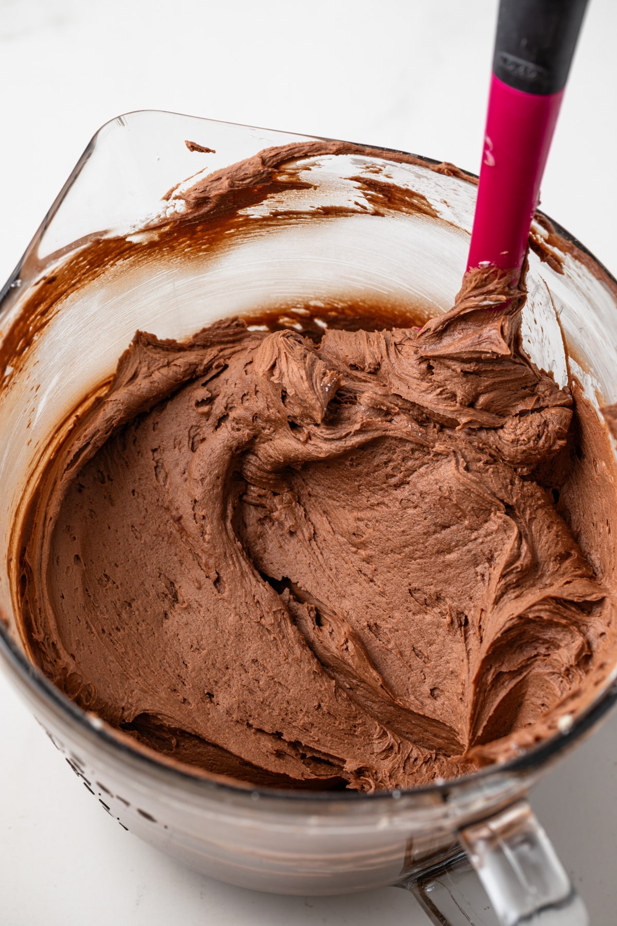 Chocolate frosting in a glass bowl.