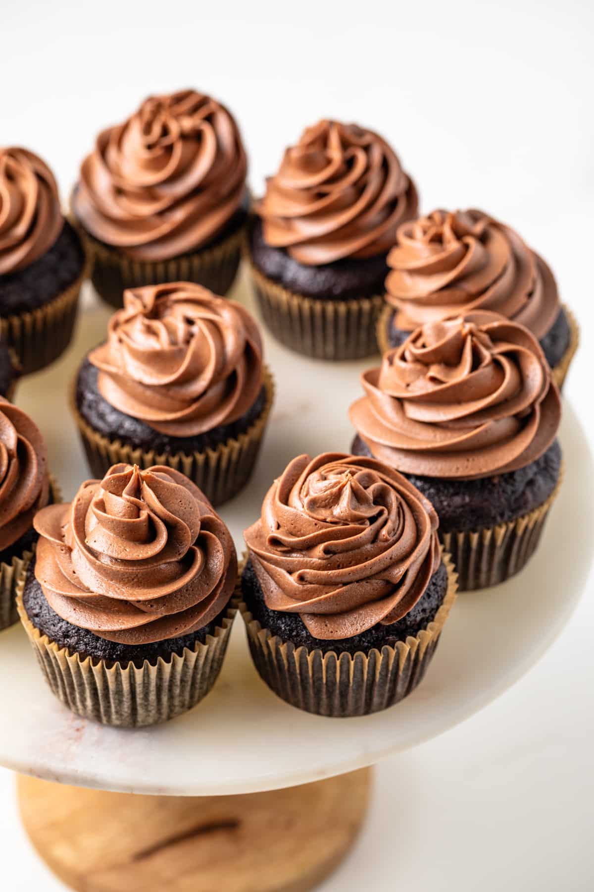 Overhead angled view of chocolate zucchini cupcakes on a cake stand.